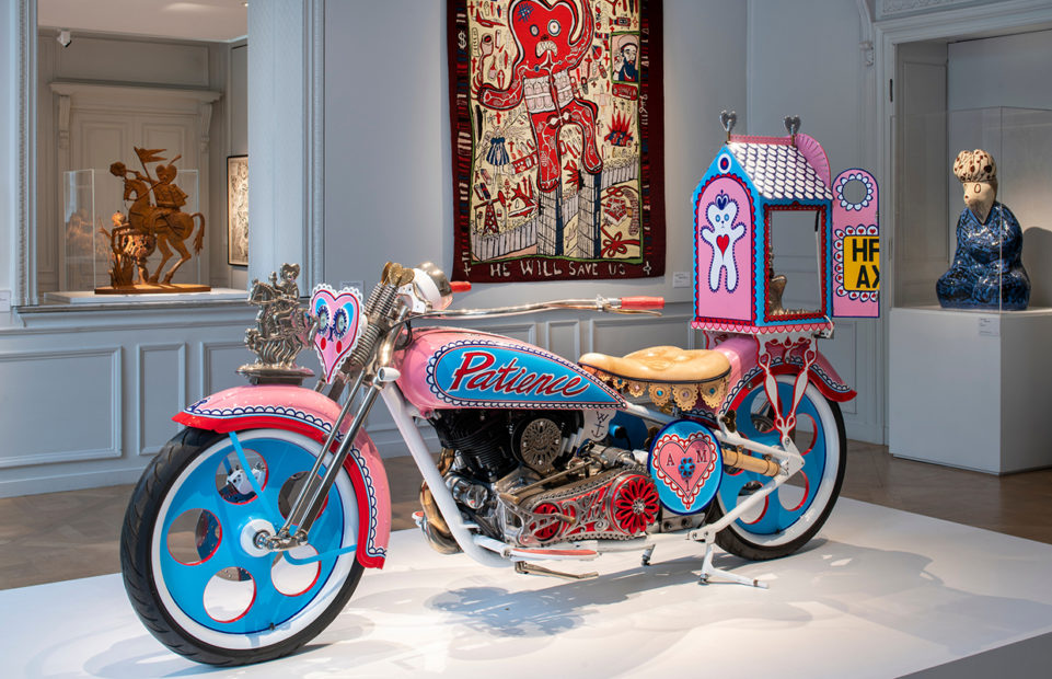Perry has long had a fascination with customised motorbikes but when he had his own made he wanted to use it to contradict the many macho images associated with the vehicle. Feminine pink and frills and the words “Patience” and “Humility” dominate the bike. It is also a homage to his teddy bear, Alan Measles, who appears as a victorious warrior at the front of the bike and as a beatific guru figure in a shrine at the back, depicting Perry’s concepts of masculine and feminine experience.