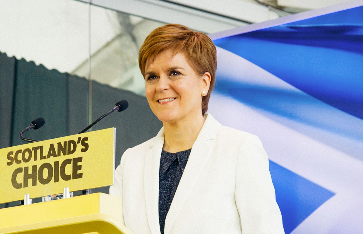 Scottish First Minister and SNP leader Nicola Sturgeon with a Scottish Flag and a lectern reading Scotland's Choice