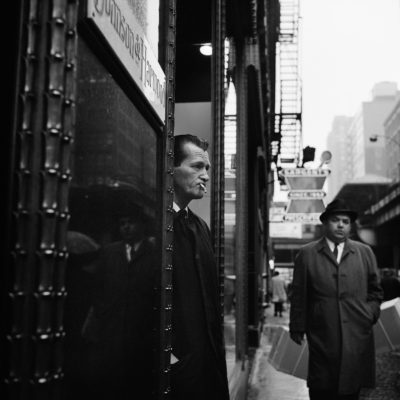 A man smoking in a doorway.