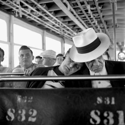 An elderly couple asleep on a bus.