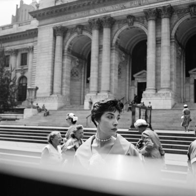 A glamorous woman standing outside New York Public Library