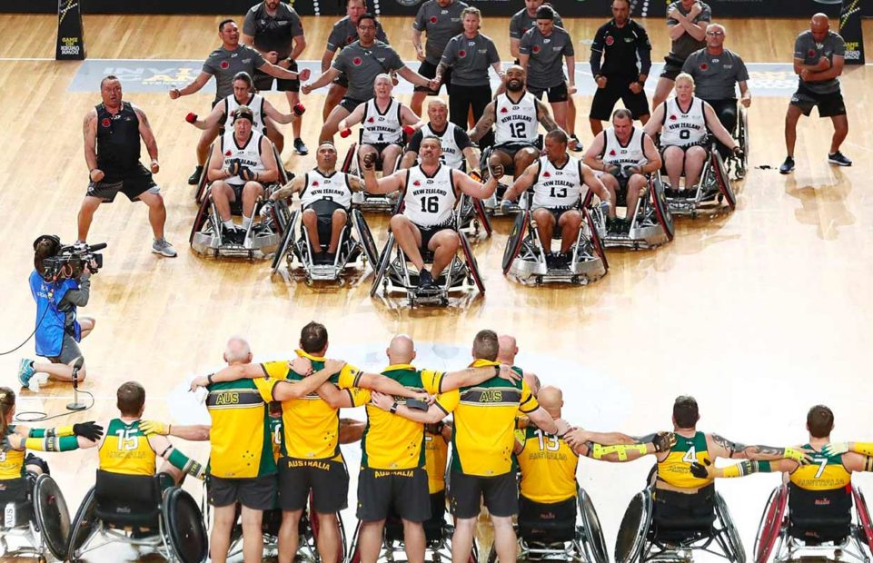 The New Zealand wheelchair rugby team does a haka while their opponents watch.