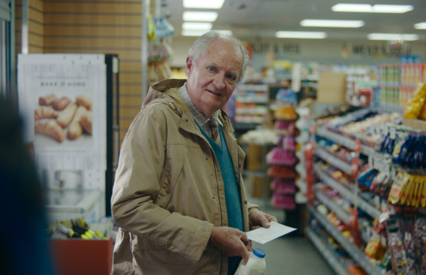 Jim Broadbent as Harold Fry in a shop holding a letter. 