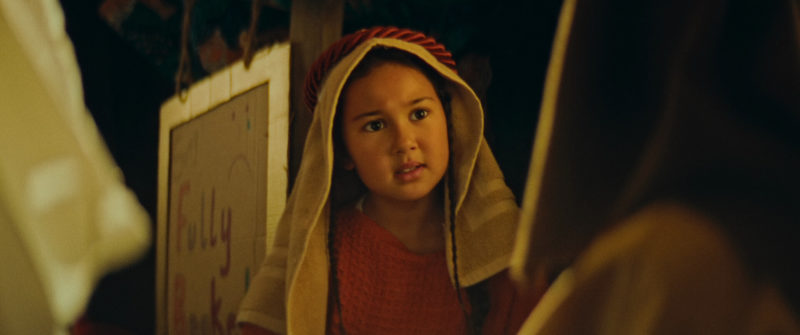 A still from the film The Innkeeper. We see a girl in a stage Arabic headdress looking intently at the camera.
