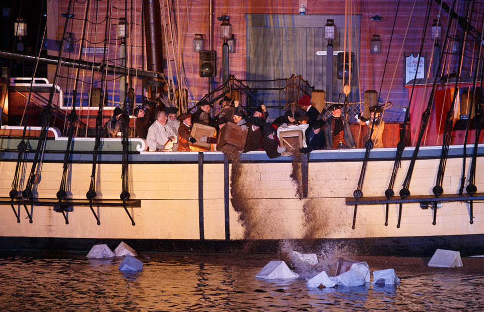 A reenactment of the Sons of Liberty throwing tea crates overboard at the Boston Tea Party