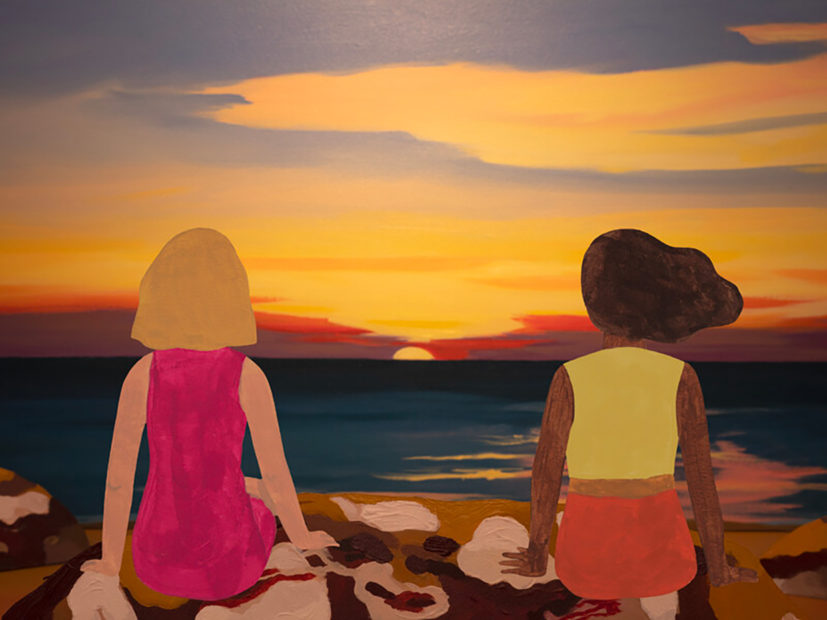 A still from the short film Darwin Story showing two young women from behind, sitting looking at a sunset or sunrise.