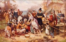 An artist's impression of the first Thanksgiving meal with pilgrims giving food to their Native American guests.