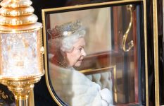 Queen Elisabeth II in crown and ceremonial robes in the state coach.