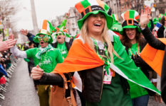 People dressed in green white and orange at a St Patrick's Day parade.