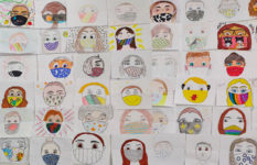 Pupils' portraits with masks and with adjectives to describe themselves.