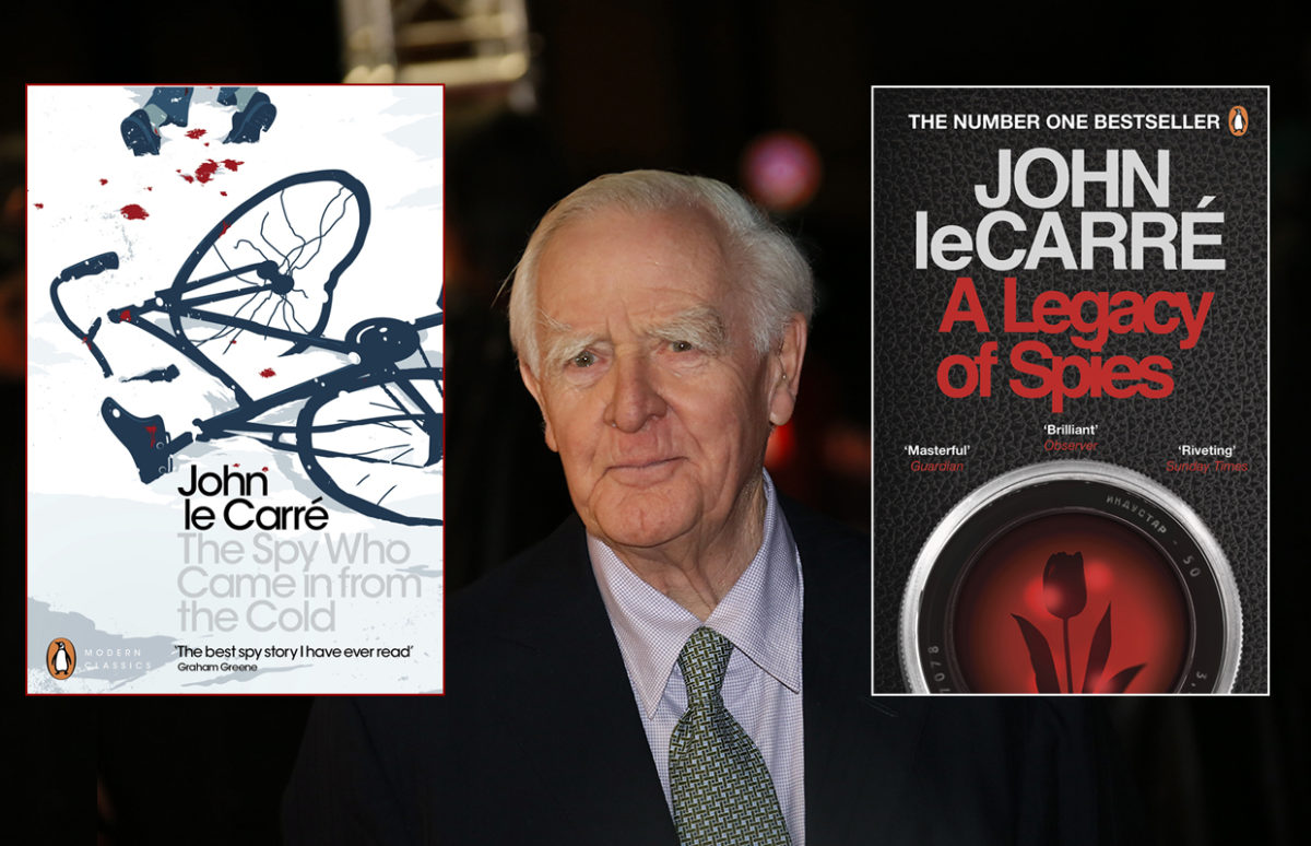 John le Carré flanked by two of his Smiley novels.