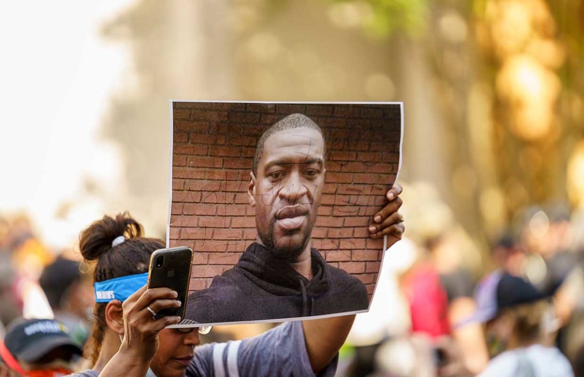 A protester holds a photo of George Floyd.