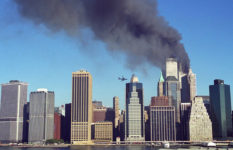 United Airlines Flight 175 moments before it was flown into the South Tower. Smoke can be seen billowing from the North Tower.