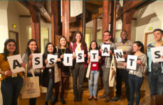 A group of young people holding the letters that make up the word Assistants.
