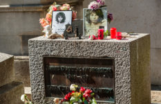 Jim Morrison's grave with flowers, candles and photos left by fans.