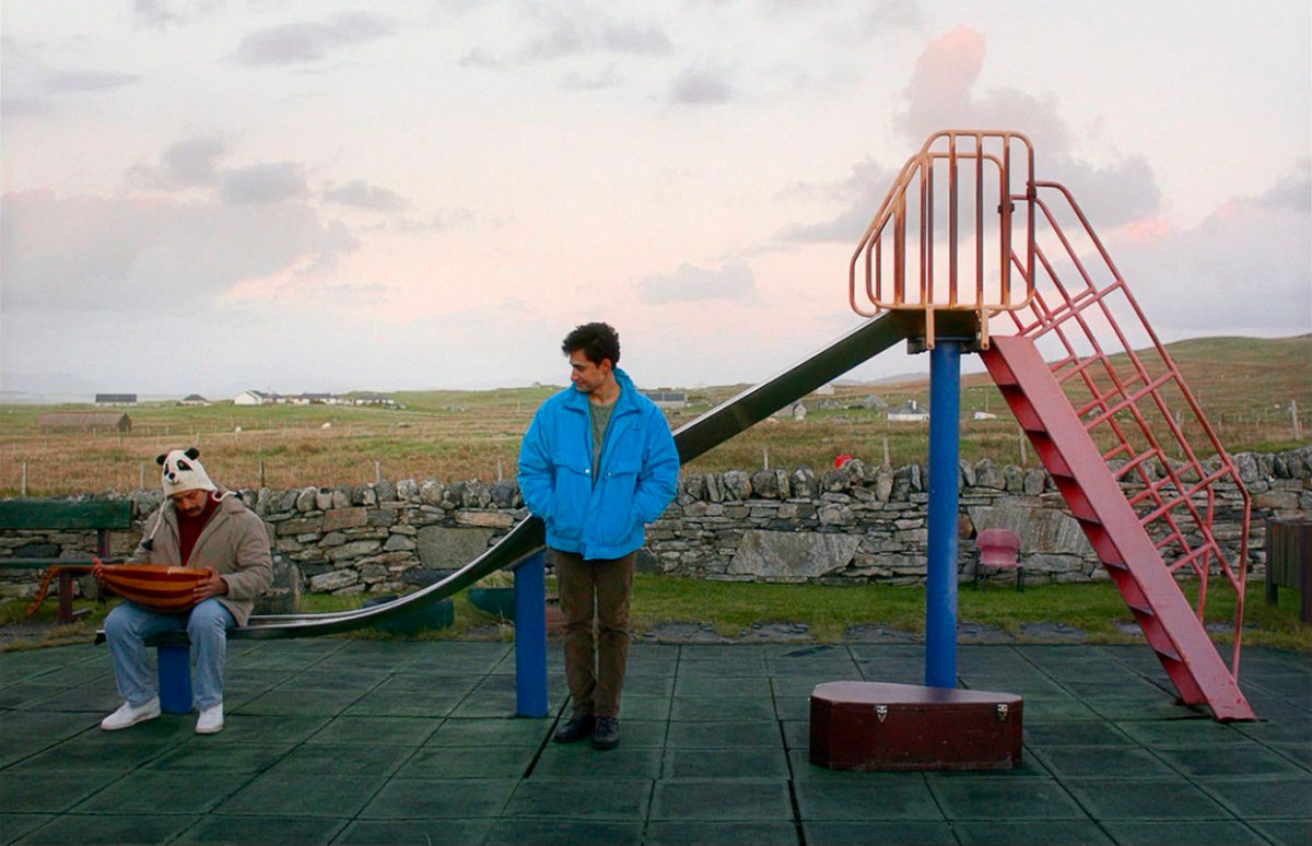 Two men in a children's playground, from the film Limbo.