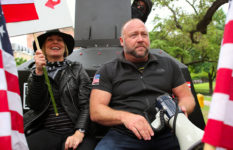 Alex Jones, right, at an April, 2020 rally in Austin, Texas, opposing COVID stay-at-home orders.
