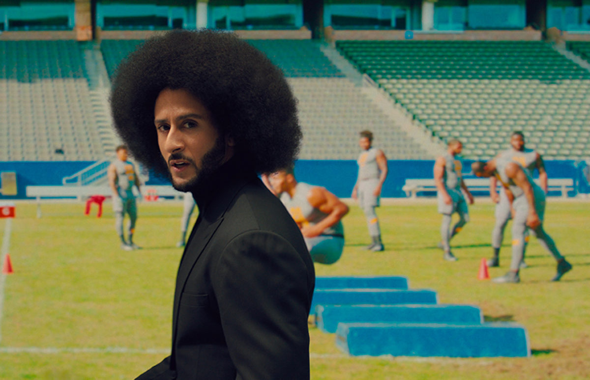 Colin Kaepernick with American football players trying out in the background.