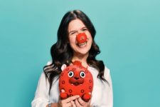 Comedian, actress and disability activist Rosie Jones modelling Red Nose Day merchandise.