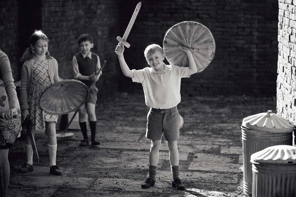 Jude Hill as Buddy. playing a game with an improvised sword and shield