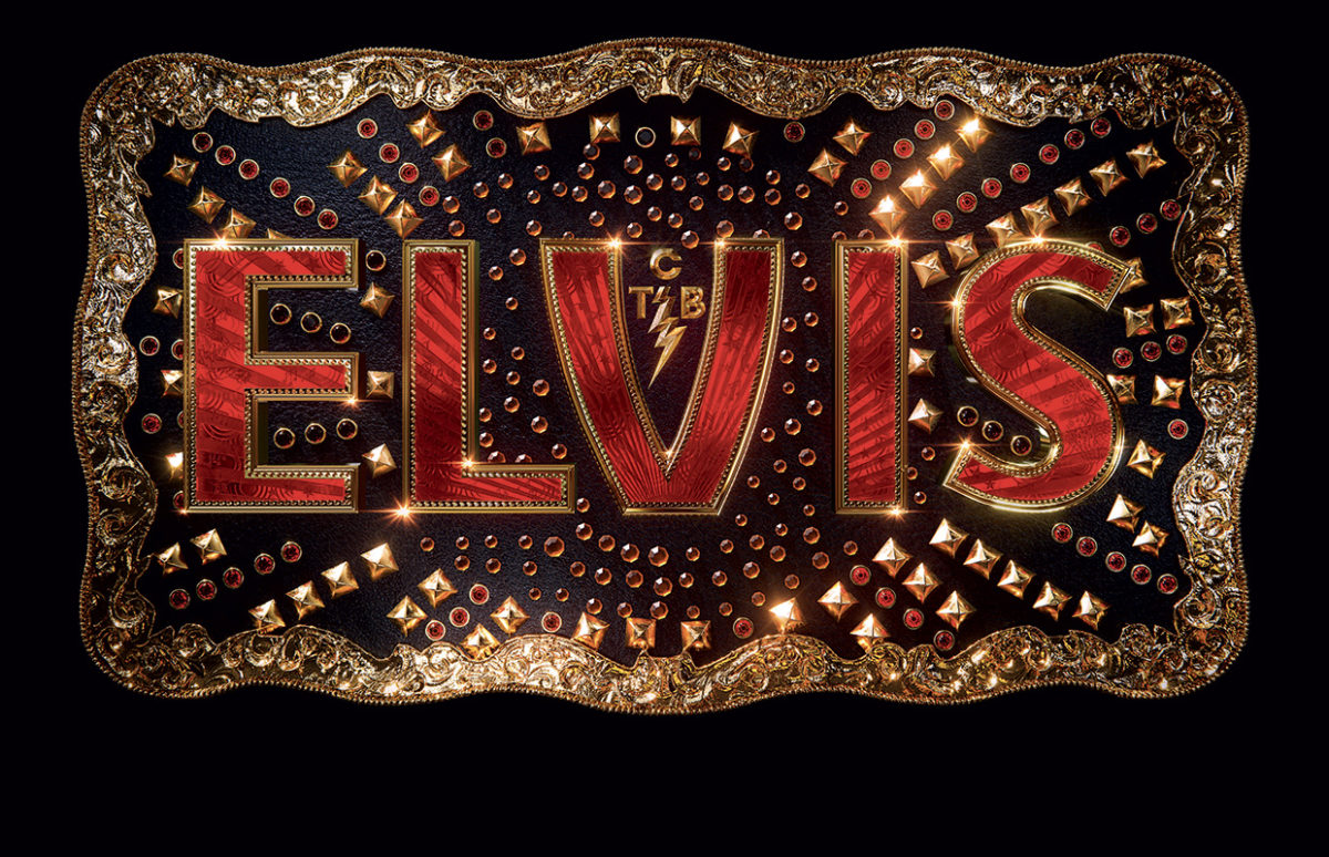 A belt buckle with ELVIS in red letters