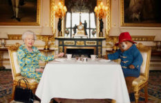 The Queen having tea at a table with Paddington Bear.