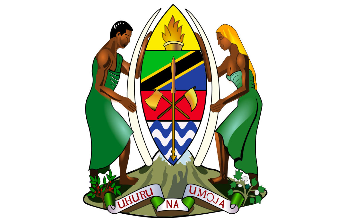 Tanzania's coat of arms, a shield with a man at the right and a woman at the left. The motto reads "Freedom and Unity" in Swahili.