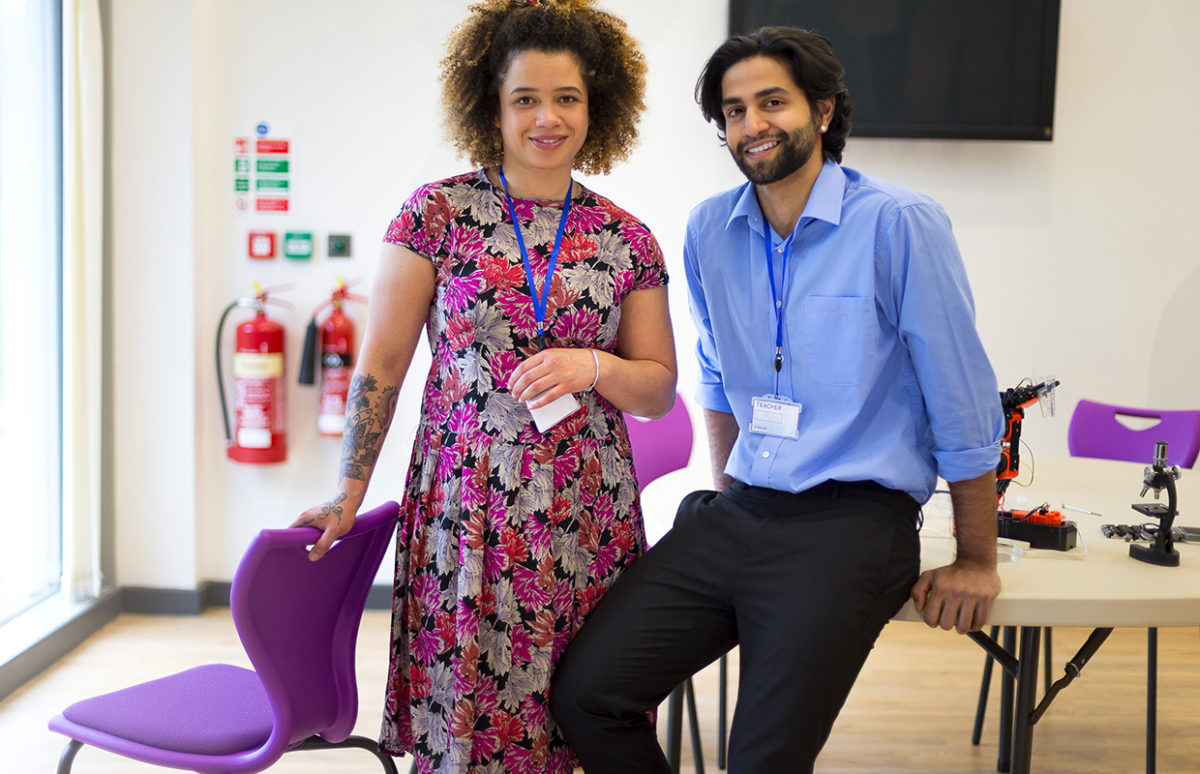 Two teachers in a classroom, facing the camera.