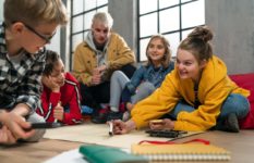 A group of pupil working on a project together as the teacher looks on.