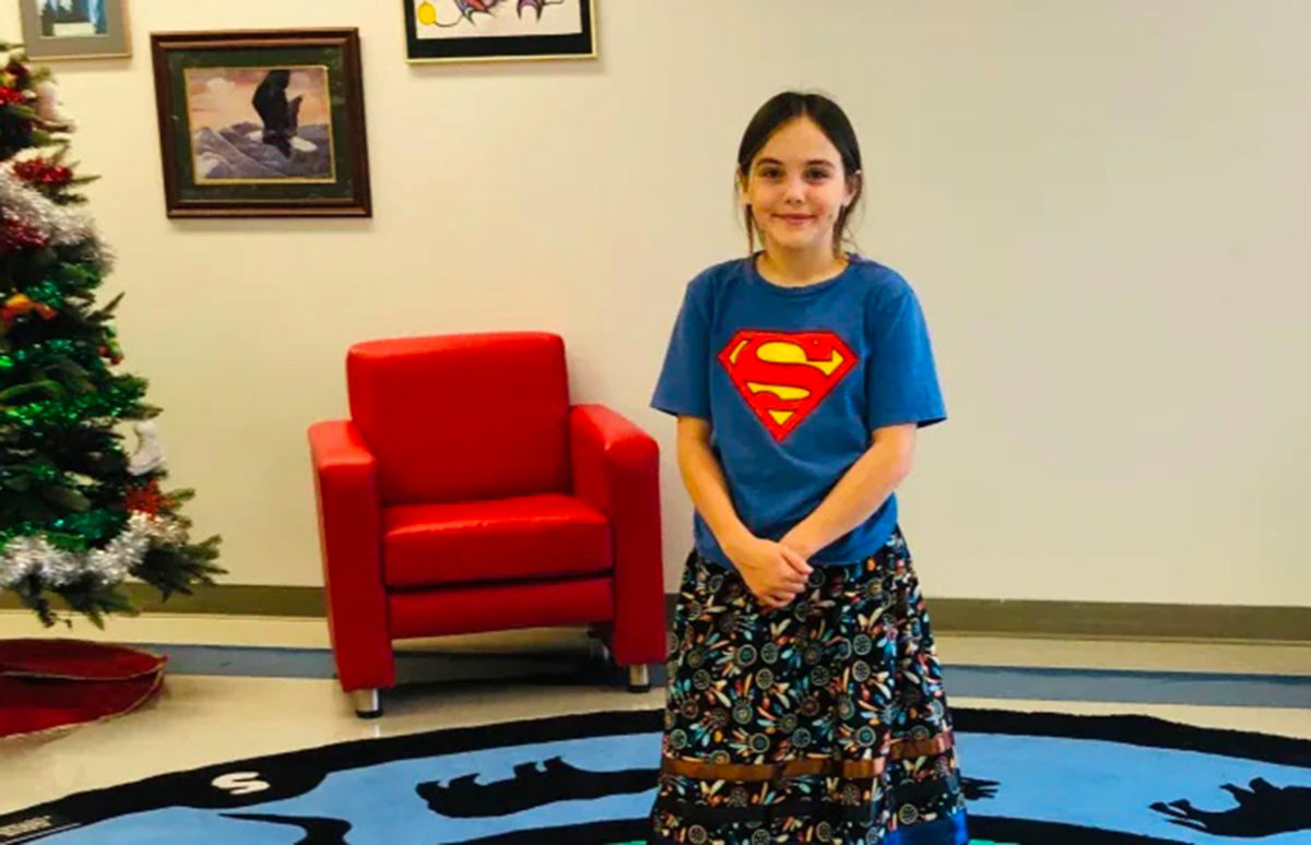 Isabella Kulak, 12, in her ribbon skirt and a Superman T-shirt.