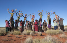 Tjanpi Desert Weavers Artists holding up their Seven Sisters representations, Papulankutja, Western Australia, 2015