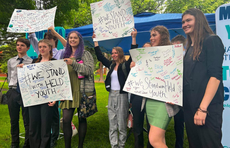 A group of the plaintiffs in the case, including Rikki Held (far right), holding posters made by young supporters.