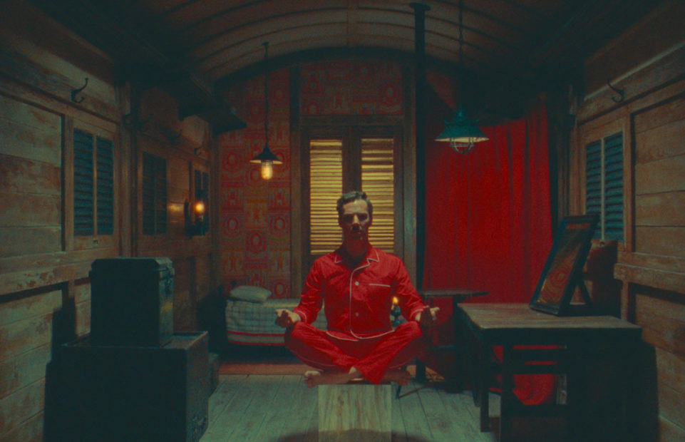 Benedict Cumberbatch as Henry Sugar, sitting with his legs crossed looking like he is levitating.