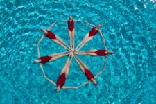 Seven synchronised swimmers making a star shape.