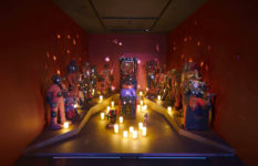 A candlelit room in the exhibition filled with voodoo talismans.