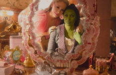 Ariana Grande is Glinda and Cynthia Erivo is Elphaba in Wicked, looking into a mirror in their dormroom.
