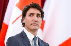 Justin Trudeau in front of a Canadian flag.