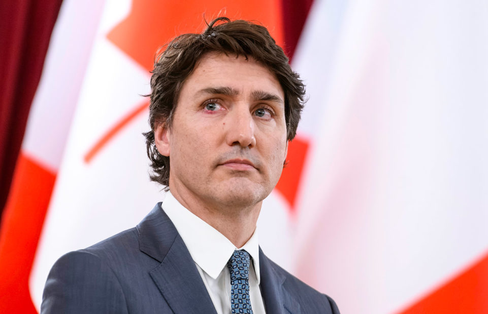 Justin Trudeau in front of a Canadian flag.