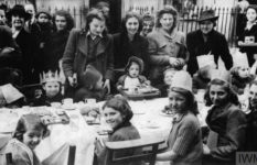 Women and children at a street party for VE Day.