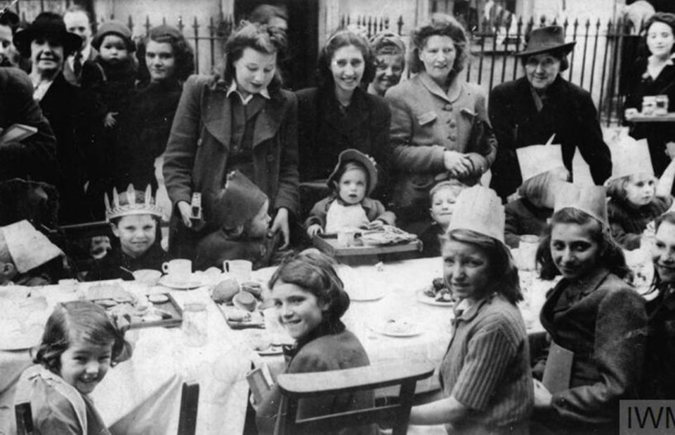 Women and children at a street party for VE Day.
