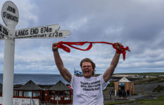 Marcus in front of the marker at John O'Groats at the end of his challenge.