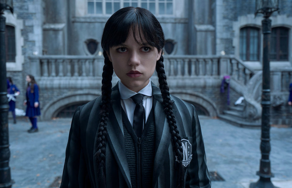 Jenna Ortega as Wednesday Addams, in school uniform in the courtyard of Nevermore School.