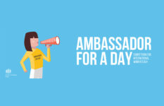 A young woman with a megaphone and banner saying Ambassador for a Day