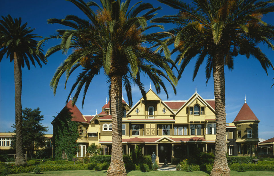 A large nineteenth century house with palm trees in the foreground